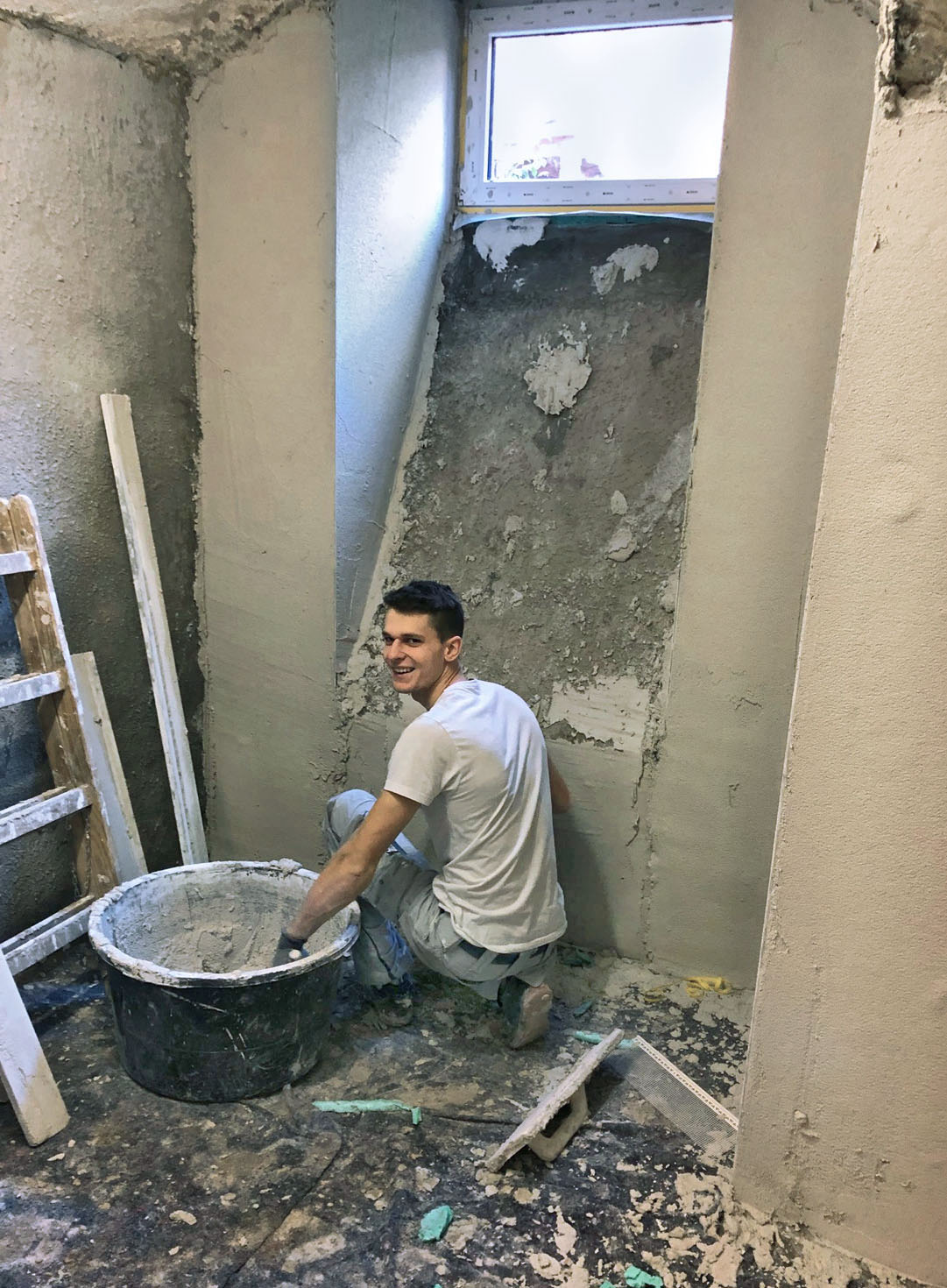 Faistauer-Handwerker verputzt fachgerecht die Laibung an einem Kellerfenster